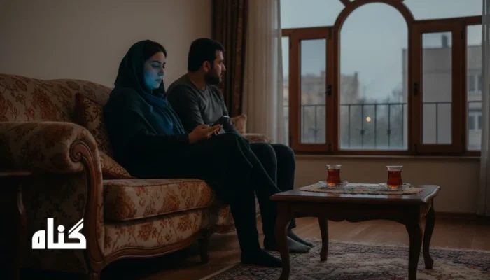 دو نفر روی مبل در خانه، کنار هم اما دور از هم؛ تصویری از حضور بدون توجه در رابطه نزدیک