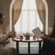 دو نفر در گفت وگویی آرام؛ یکی در حال حرف زدن و دیگری با دفترچه و چک لیست خط خورده، نماد نصیحت ناخواسته و فاصله عاطفی